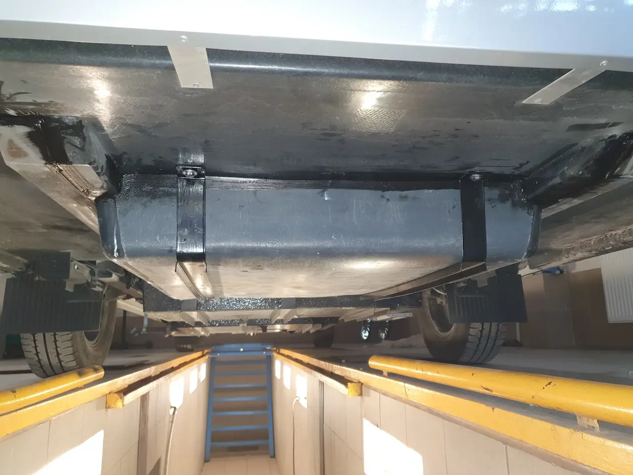 Kempera rezerves riteņa turētāja uzstādīšana garāžas nodalījumā zem grīdas. Rezerves riteni var izņemt no iekšpuses.